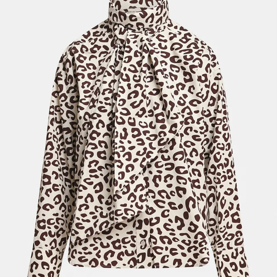 A long-sleeve blouse with a high mock neck and a large front bow, featuring a brown leopard print pattern on a cream background.