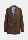 A brown double-breasted blazer with a subtle plaid pattern, featuring gold-tone buttons, a striped blue and white shirt underneath, and a red patch on the sleeve, shown against a light gray background.