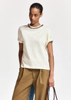 woman wearing White tshirt with a chain and brown trousers on  a white background