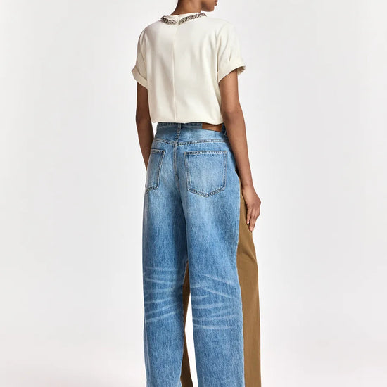 woman wearing White tshirt with a chain and brown trousers on  a white background rear view