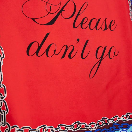 A close-up of a red fabric item, likely a scarf or bandana, featuring the phrase 'Please don't go' in black cursive script. The bottom edge is decorated with a multicolor chain-link pattern in shades of blue, white, and brown.