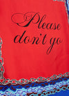 A close-up of a red fabric item, likely a scarf or bandana, featuring the phrase 'Please don't go' in black cursive script. The bottom edge is decorated with a multicolor chain-link pattern in shades of blue, white, and brown.