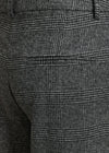 Close-up of dark gray and black plaid trousers showing the fabric texture and a side pocket.