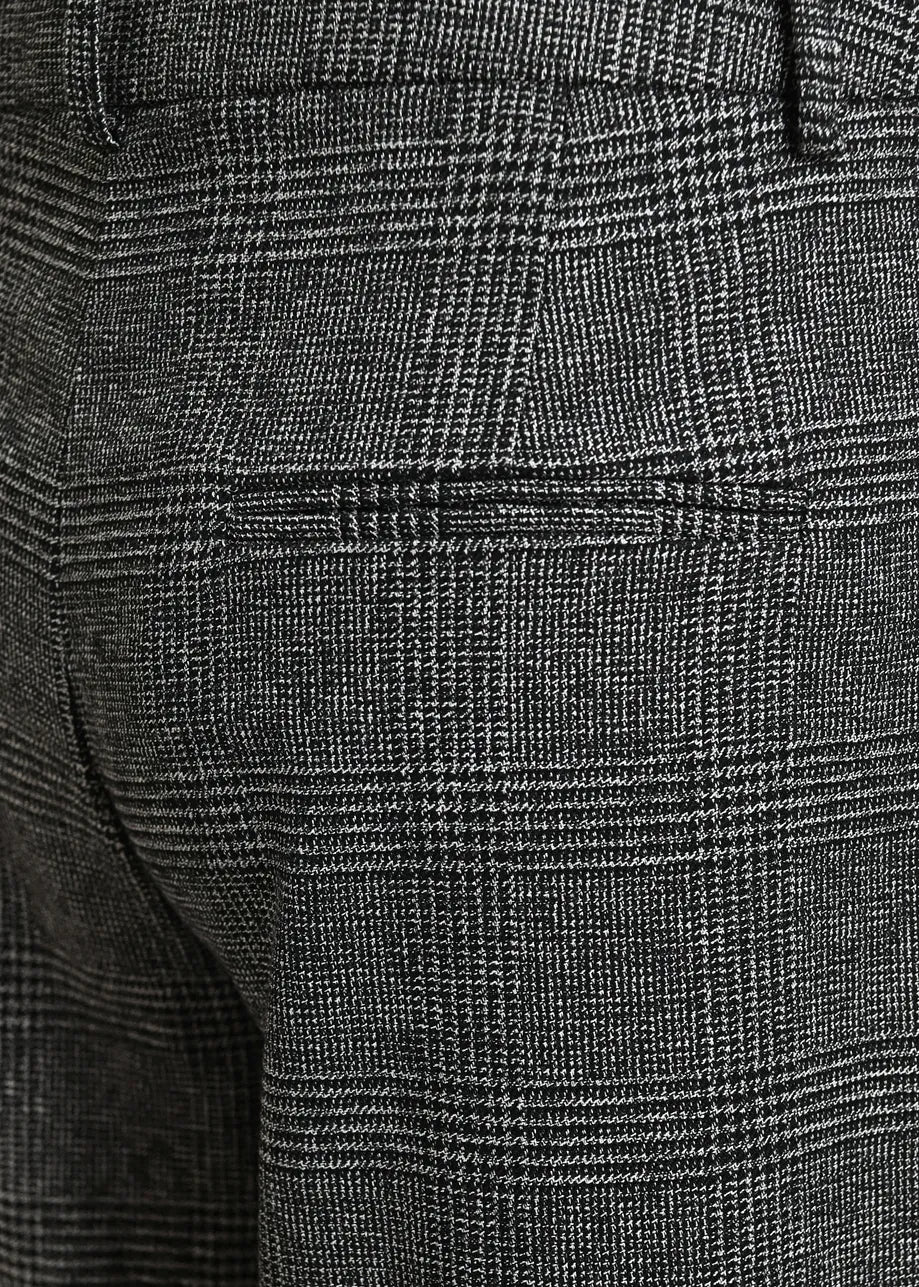 Close-up of dark gray and black plaid trousers showing the fabric texture and a side pocket.