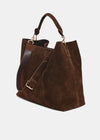 A dark brown suede tote bag with a matching brown leather shoulder strap and gold-tone hardware, shown on a light gray background.