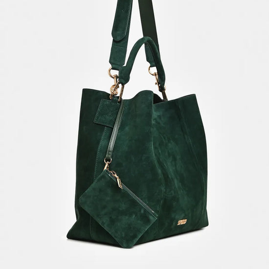 A dark green suede tote bag with a matching detachable shoulder strap and a small matching pouch, featuring gold-tone hardware on a light gray background.