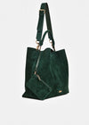 A dark green suede tote bag with a matching detachable shoulder strap and a small matching pouch, featuring gold-tone hardware on a light gray background.