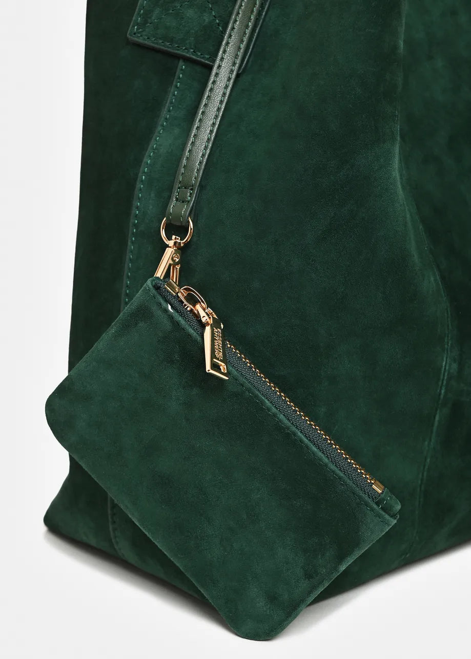 Close-up of a dark green suede tote bag with a matching shoulder strap and a small zippered pouch attached by gold-tone hardware.