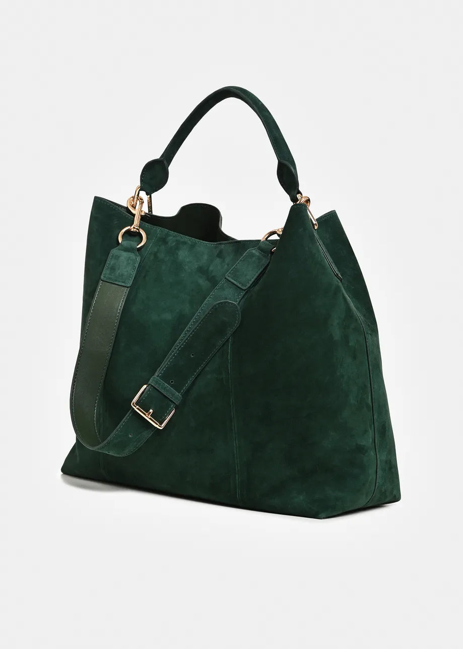 A dark green suede tote bag with a matching shoulder strap, gold-tone hardware, and top handles, shown on a light gray background.