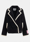 A black sherpa fleece wrap jacket with cream-colored contrast piping and trim, featuring a pointed lapel design, front pockets, and a pink 'ESSENTIALS AUTHENTIC' patch on the left sleeve cuff, shown against a light gray background.