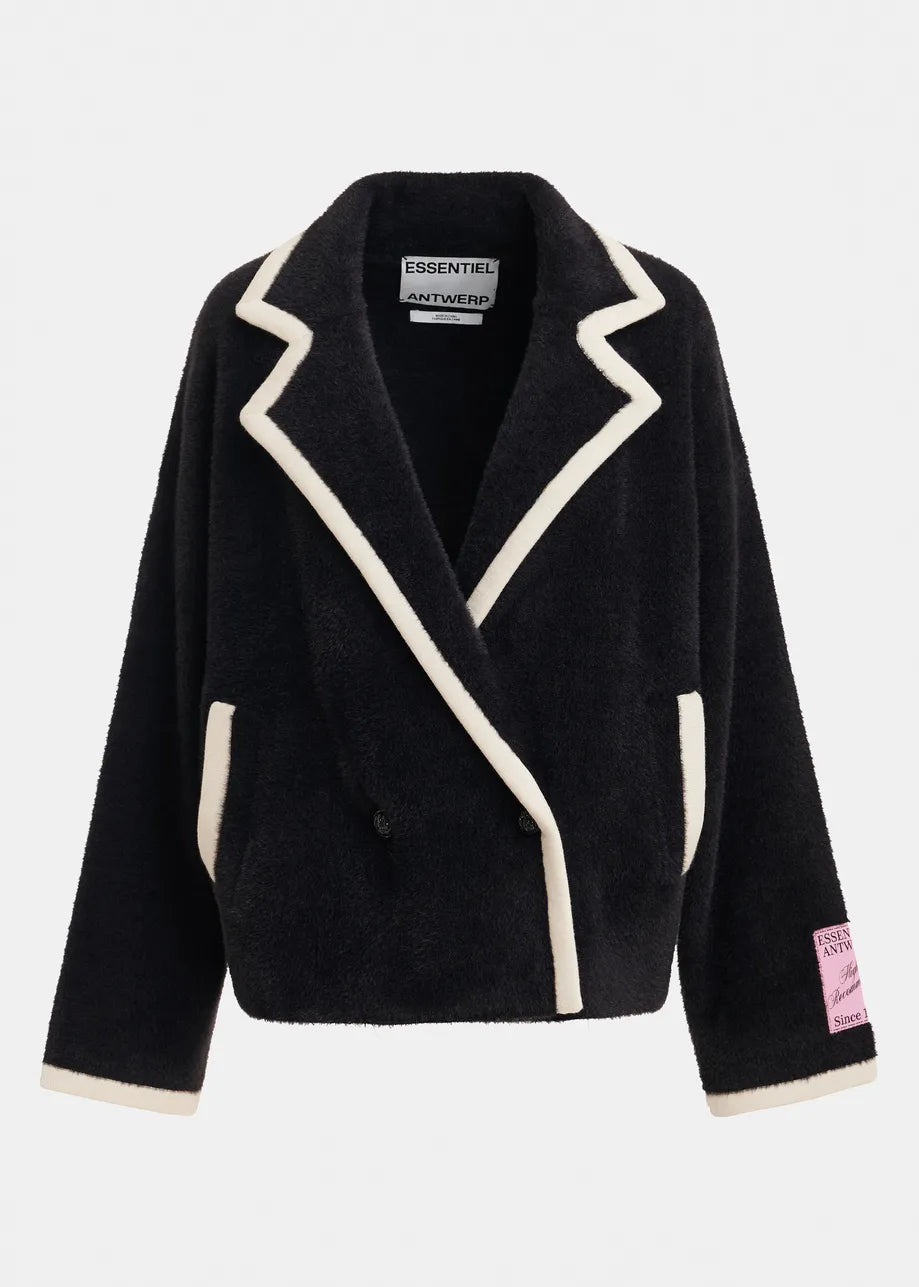 A black sherpa fleece wrap jacket with cream-colored contrast piping and trim, featuring a pointed lapel design, front pockets, and a pink 'ESSENTIALS AUTHENTIC' patch on the left sleeve cuff, shown against a light gray background.