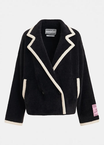A black sherpa fleece wrap jacket with cream-colored contrast piping and trim, featuring a pointed lapel design, front pockets, and a pink 'ESSENTIALS AUTHENTIC' patch on the left sleeve cuff, shown against a light gray background.