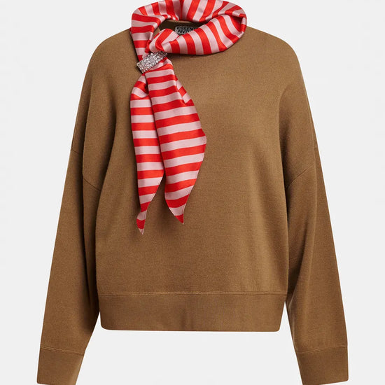 A camel brown knit sweater with a red and white striped silk scarf tied around the collar, displayed on a clean white background.