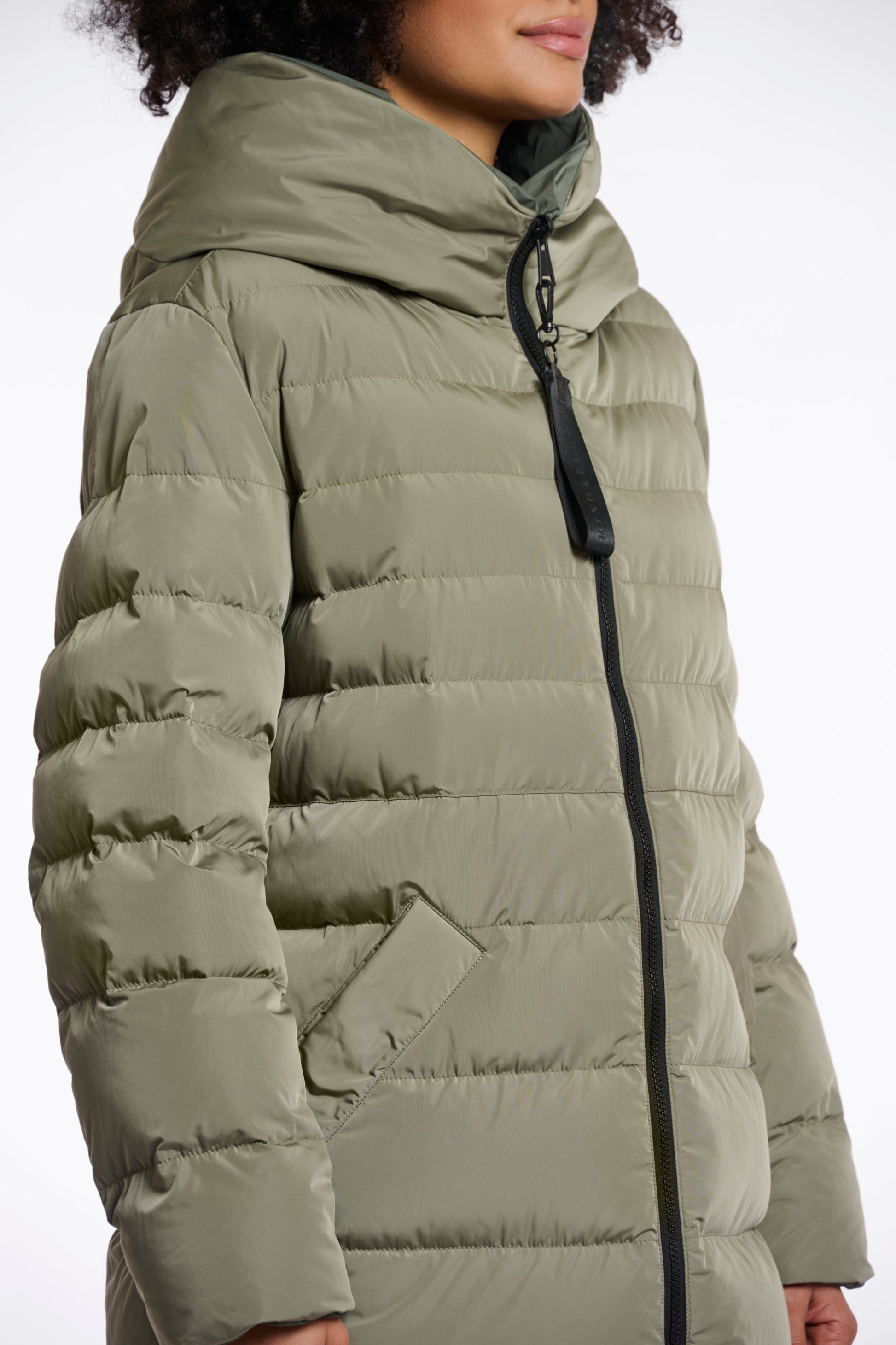 green mid length added reversible coat with matt green exterior, large hod and side pockets side view