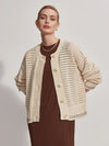 Button through pointelle knit cardigan in ecru with green details layered over a dress