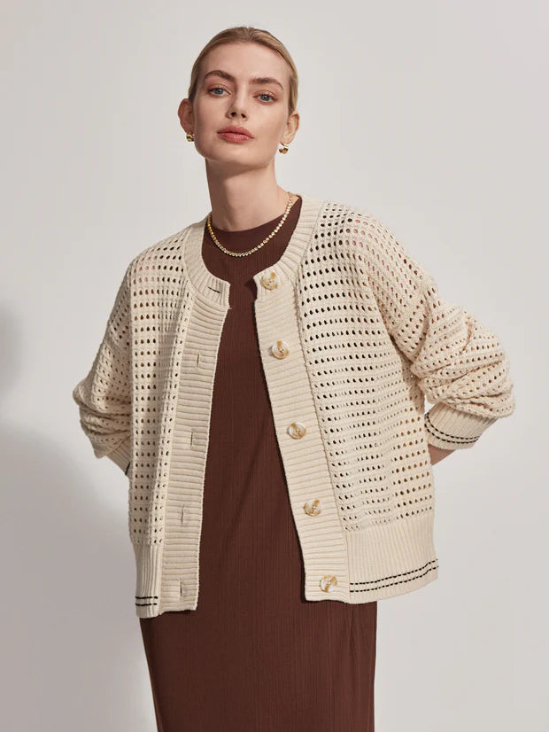 Button through pointelle knit cardigan in ecru with green details layered over a dress