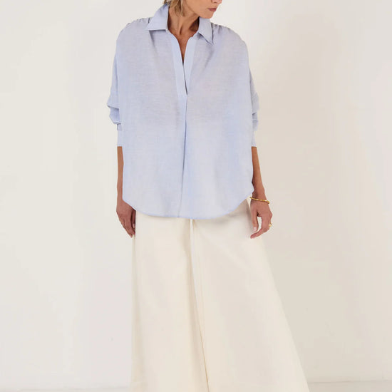Woman wearing Mondo Corsini blue and white Pinstripe blouse on a white background.