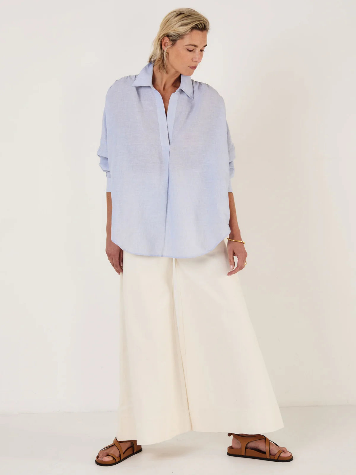 Woman wearing Mondo Corsini blue and white Pinstripe blouse on a white background.