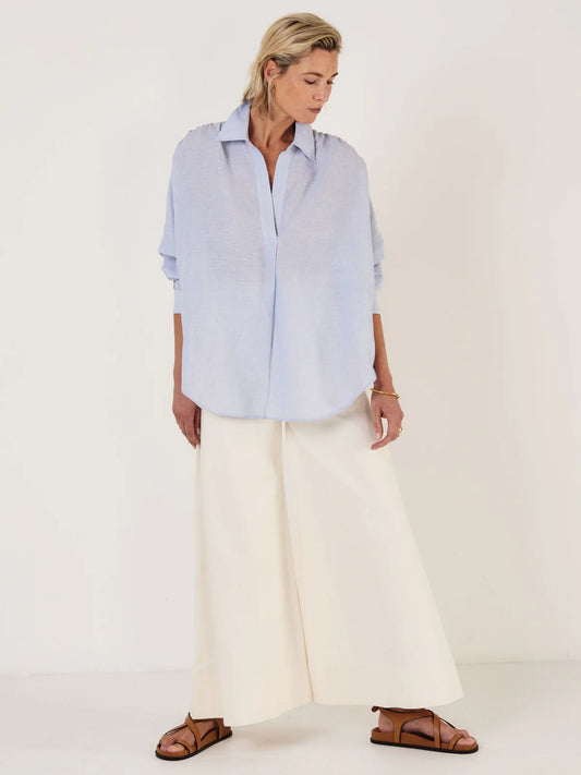 Woman wearing Mondo Corsini blue and white Pinstripe blouse on a white background.