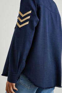 Navy heavyweight shirt with button fastening patch pockets and gold metallic fibre tripe chevron applique patches on sleeves