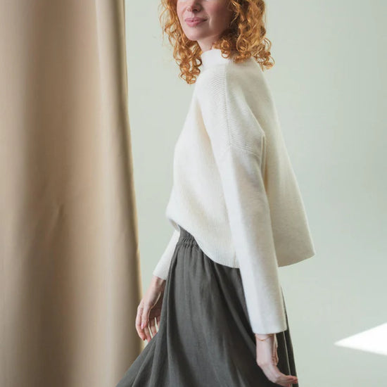 white ribbed jumper with stand neck and long sleeves side view 