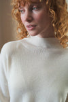 white ribbed jumper with stand neck and long sleeves close up