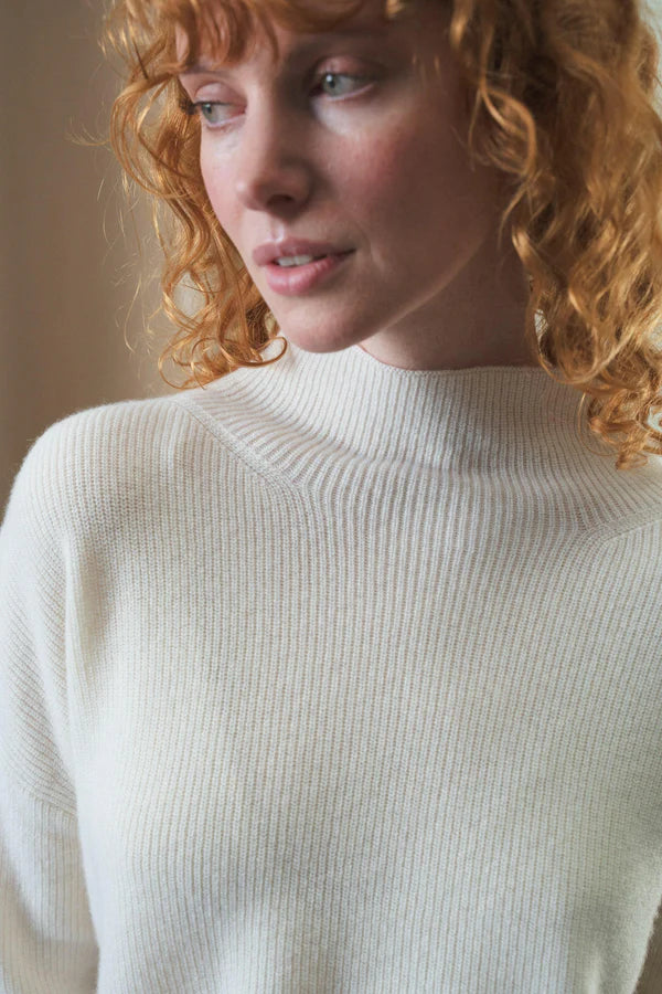 white ribbed jumper with stand neck and long sleeves close up