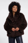 Person wearing a brown fluffy coat on a white background