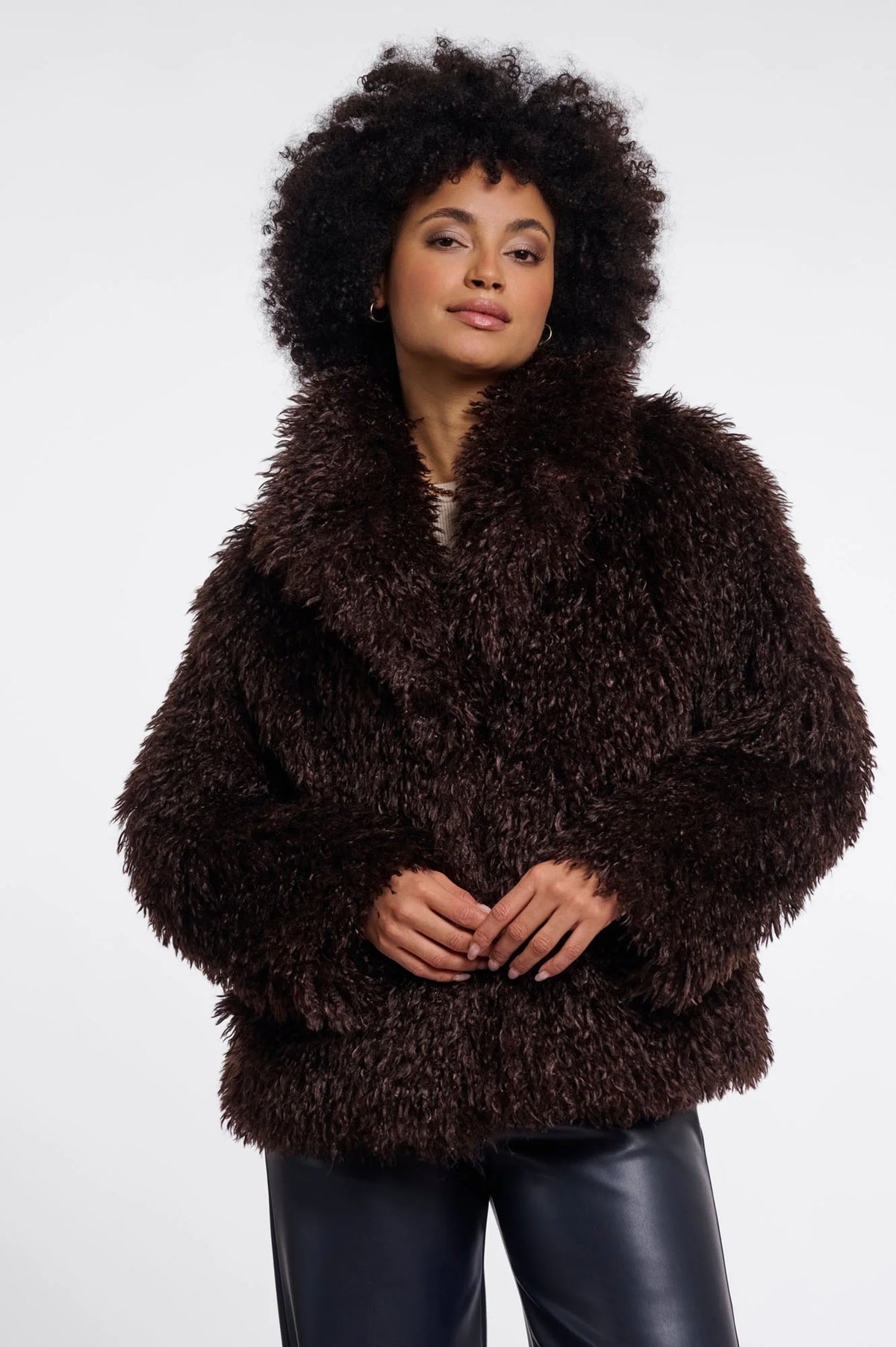 Person wearing a brown fluffy coat on a white background