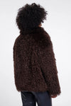 Person wearing a brown fuzzy jacket on a white background
