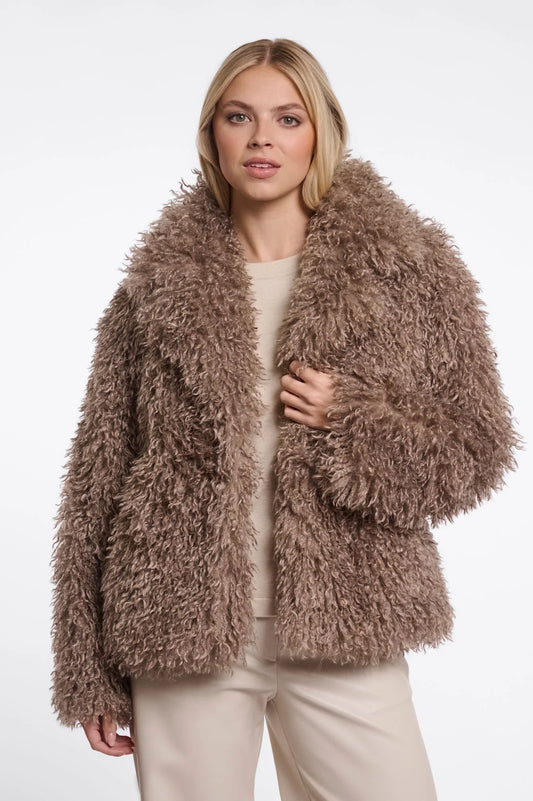 Woman wearing a fluffy brown jacket on a white background