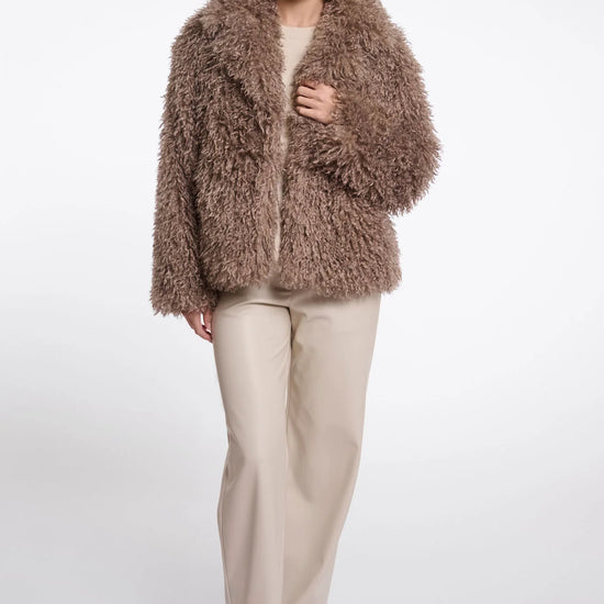 Woman wearing a fluffy brown coat on a white background