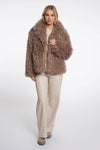 Woman wearing a fluffy brown coat on a white background