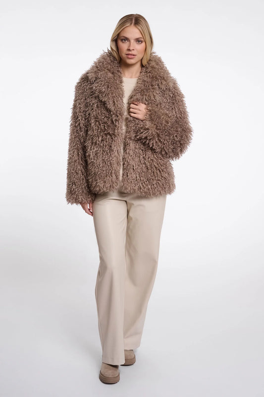 Woman wearing a fluffy brown coat on a white background