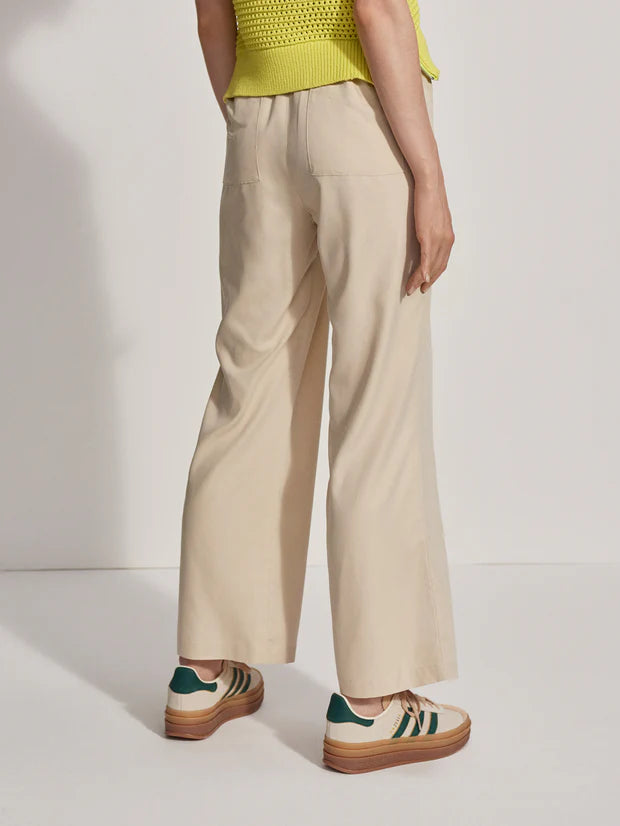 Model wearing loose fitting oyster grey trousers, side view