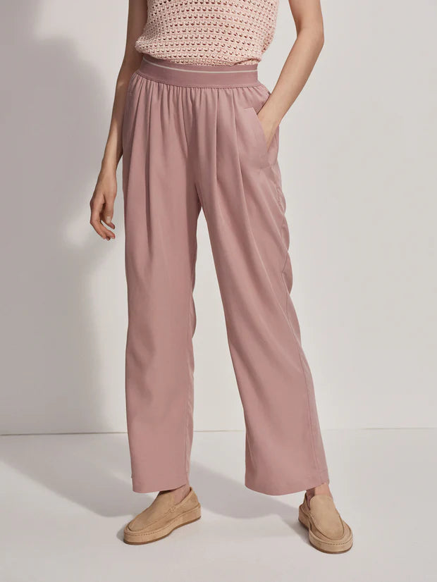 Pink pull on trousers with an elasticated waistband and side pockets model shot