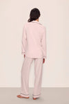 Person wearing a light pink pajama set against a plain background