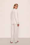 Person wearing a white pajama set against a plain background nfrom Eberjey