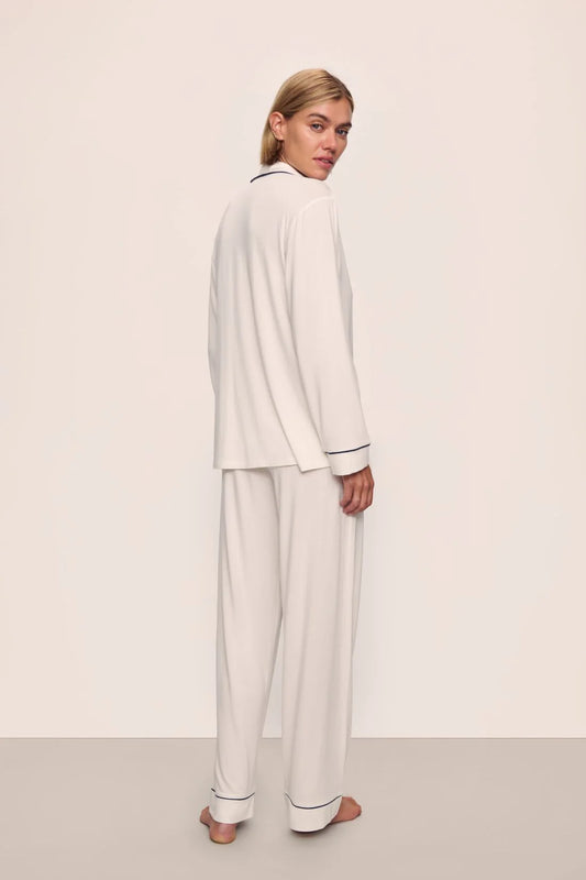 Person wearing a white pajama set against a plain background nfrom Eberjey