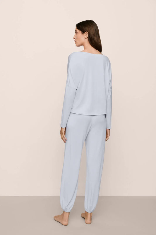 Woman wearing light blue pajamas against a beige background