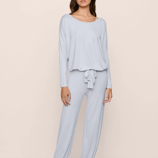 Woman wearing light blue pajama set on a beige background