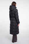 A model shown from the back wearing a long black hooded puffer coat with a belted waist, paired with dark wide-leg trousers, against a plain light gray studio background.