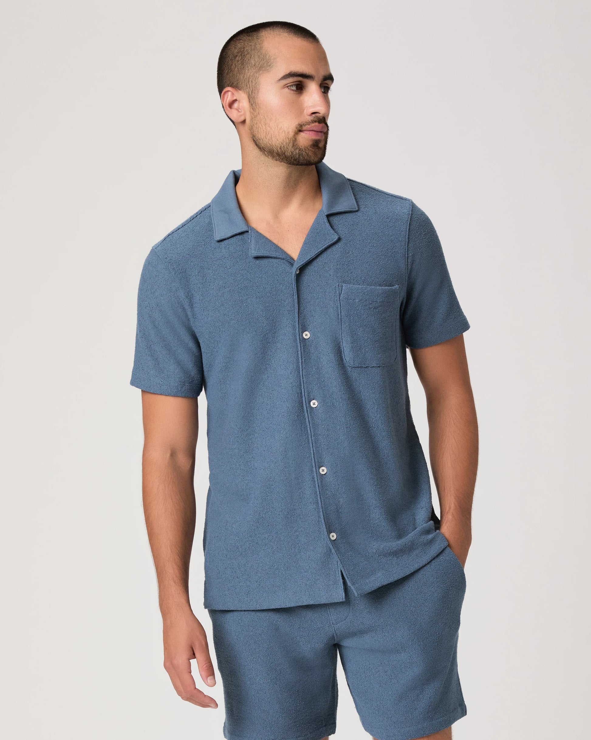 Man wearing a blue paige shirt on a white background