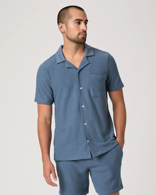 Man wearing a blue paige shirt on a white background