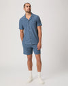 Man wearing a blue paige shirt abd matching shorts on a white background