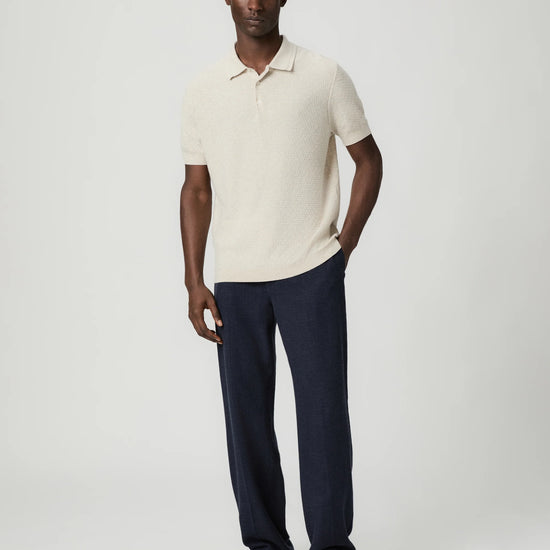 Navy blue pants with a white drawstring by Paige worn by a man on a light gray background with whole outfit 