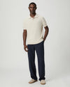 Navy blue pants with a white drawstring by Paige worn by a man on a light gray background with whole outfit 