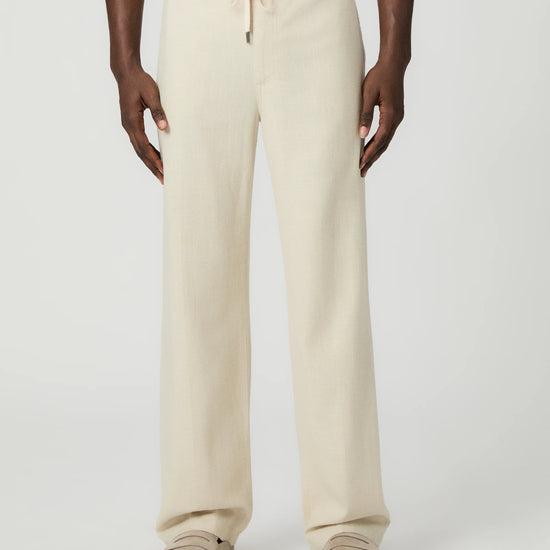 Beige paige pants worn by a man on a white background