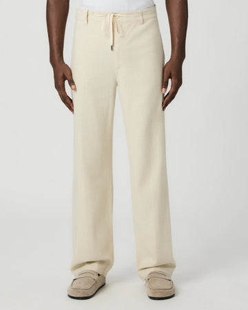 Beige paige pants worn by a man on a white background