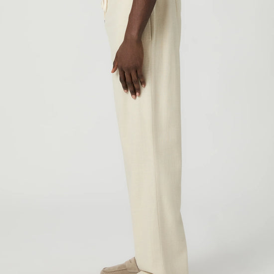 Beige paige pants worn by a man on a white background side view